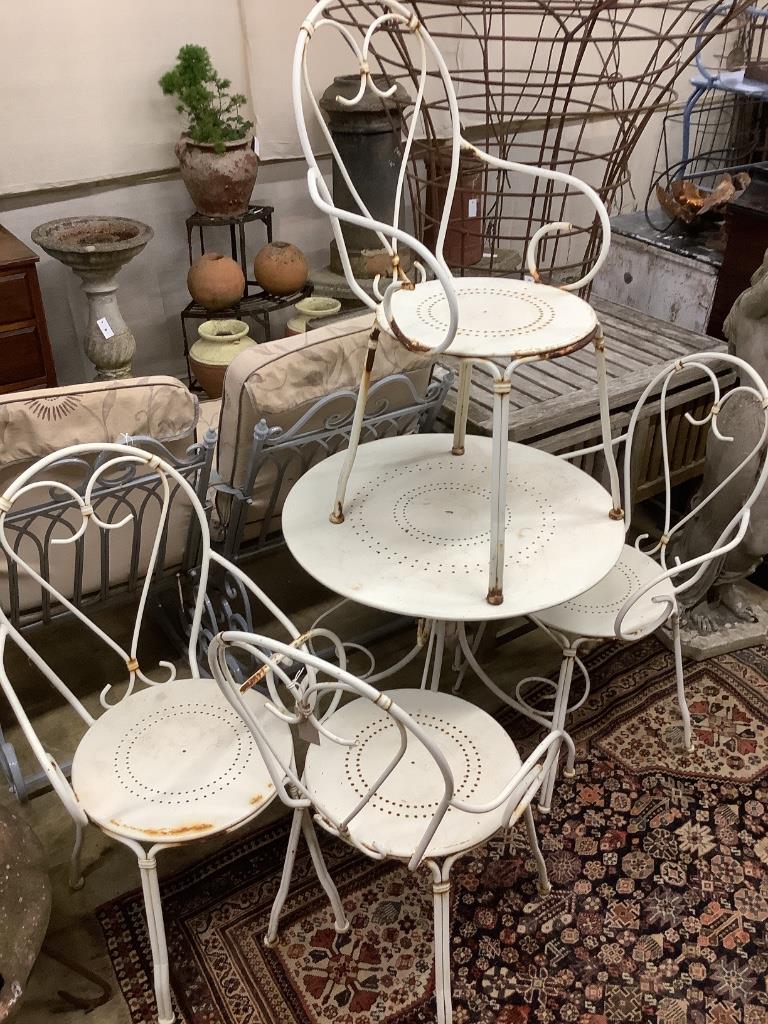 A wrought iron circular garden table, 70cm diameter, height 70cm and four chairs